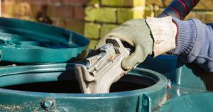 gloved hands holding oil pump